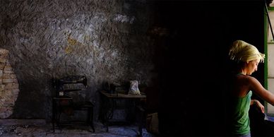 Person looking out of a window in a dimly lit room.