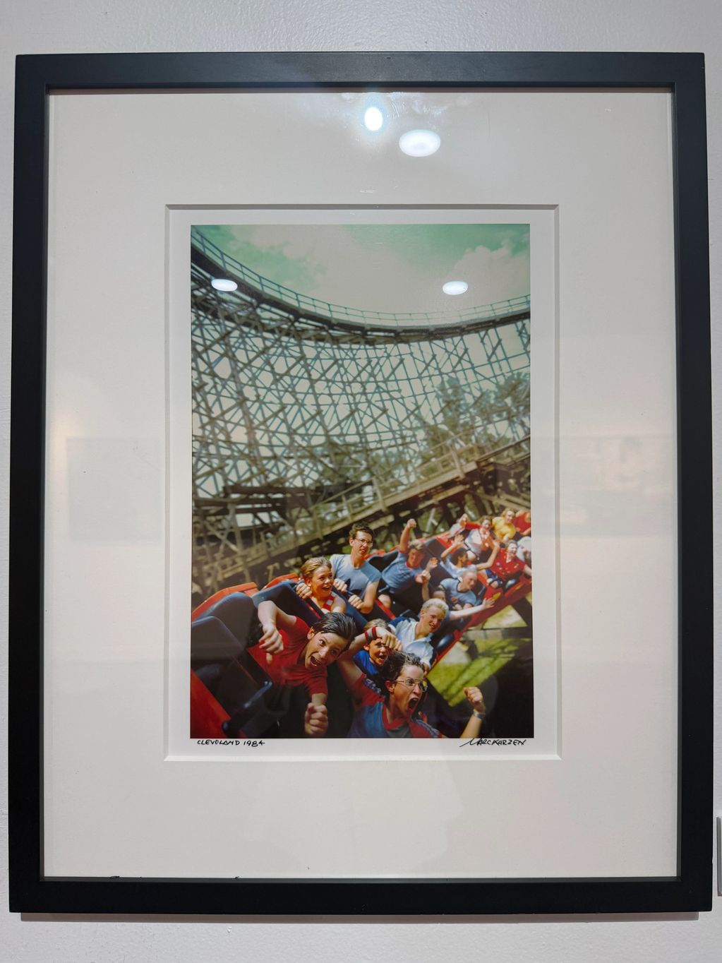 Framed photo of joyous riders on a wooden roller coaster in Cleveland, 1984.