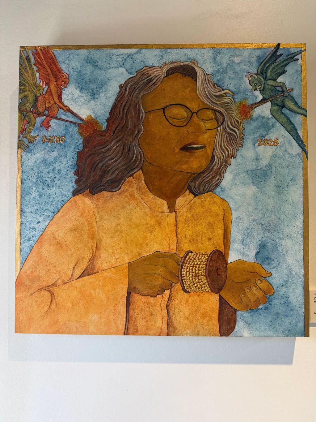 Artwork of a person with closed eyes and two small creatures breathing fire near their head.