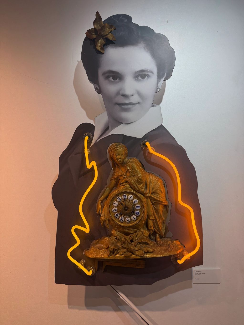 Art piece combining a vintage portrait with a decorative clock and neon lights.
