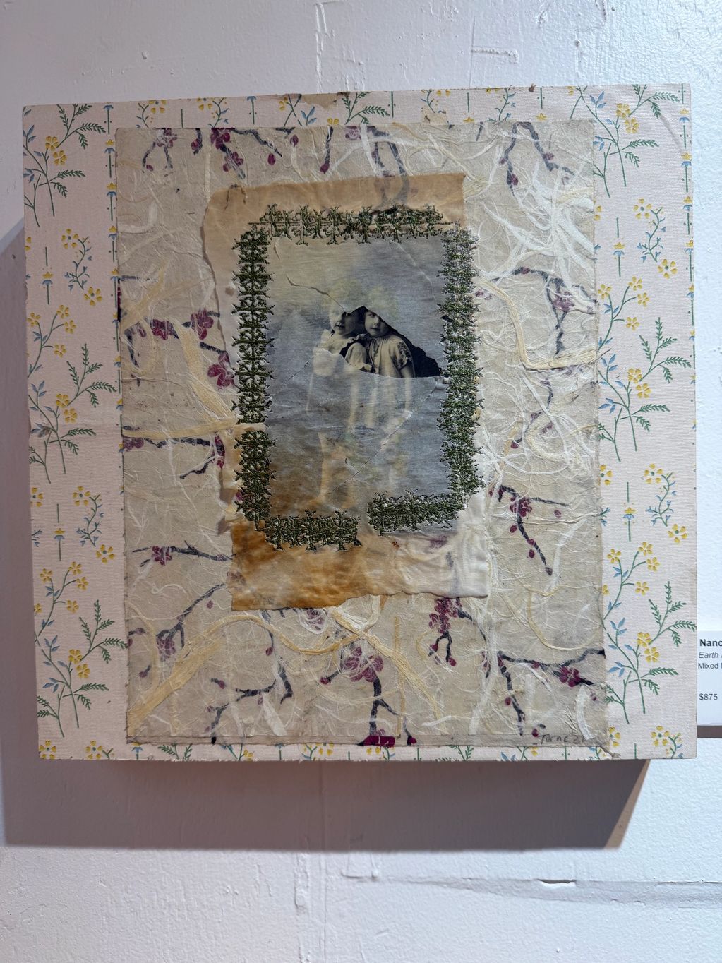 Mixed media artwork featuring a vintage photo of two children framed by textured and floral layers.