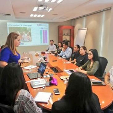 Equipo de trabajo en sala de juntas escucha a la consultora