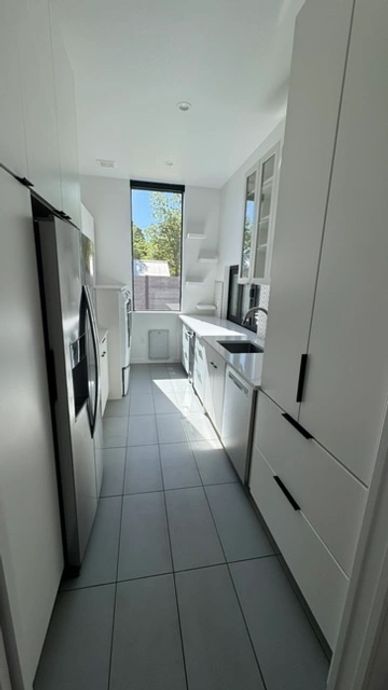 Bright and modern galley kitchen with white cabinetry.