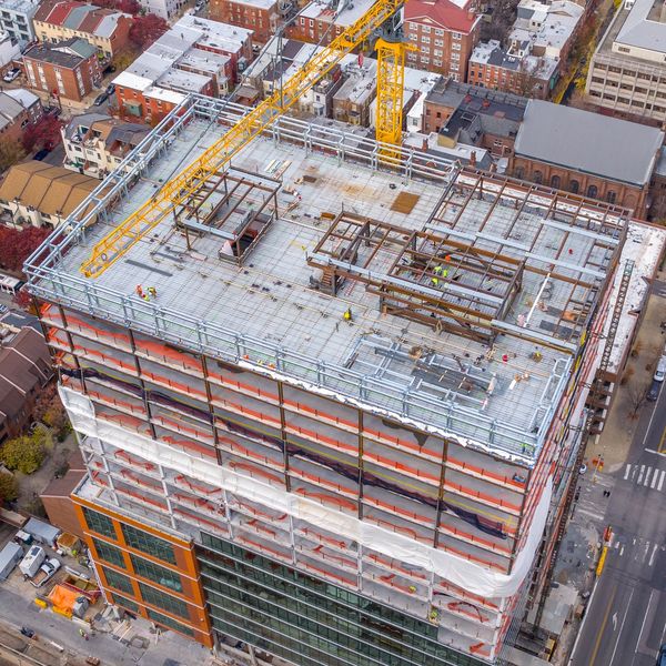 A high-rise building under construction with cranes.