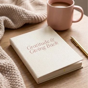 A gratitude journal with a cup of coffee and cozy blanket.