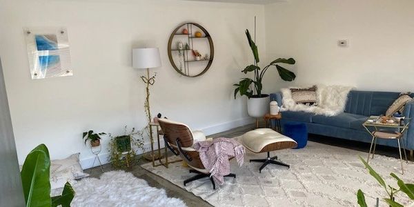 Modern living room with plants and cozy seating.