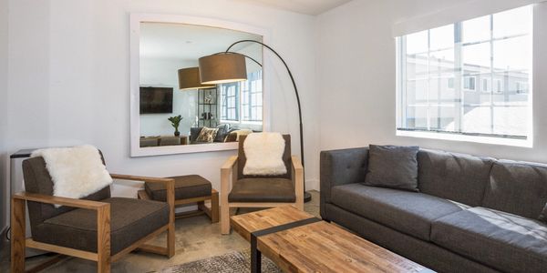Modern living room with gray furniture and wood accents.