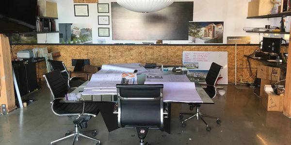 Modern office with black chairs and blueprints on the table.
