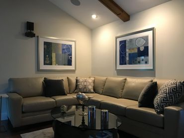 Cozy living room with a beige sectional sofa and modern abstract paintings.