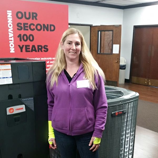 Woman standing in front of HVAC unit.