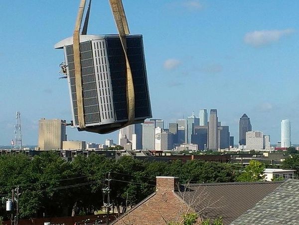 AC unit being lifted by crane.