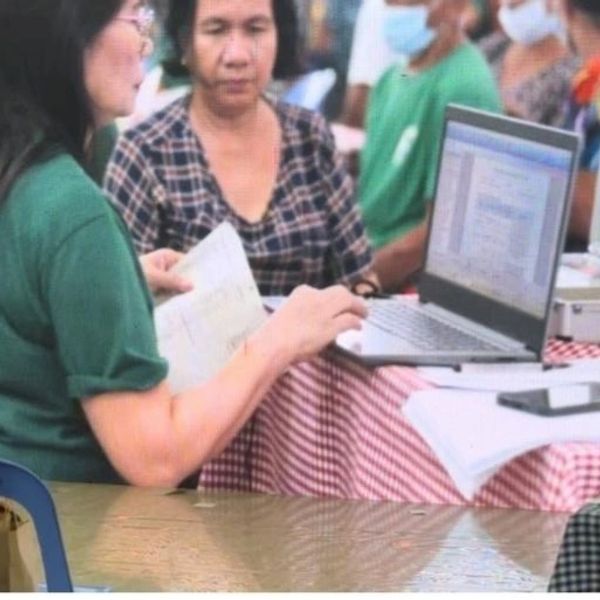 Two women engaged in a discussion with a laptop on a checkered table.