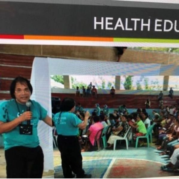 A health education session with a speaker addressing a seated audience.