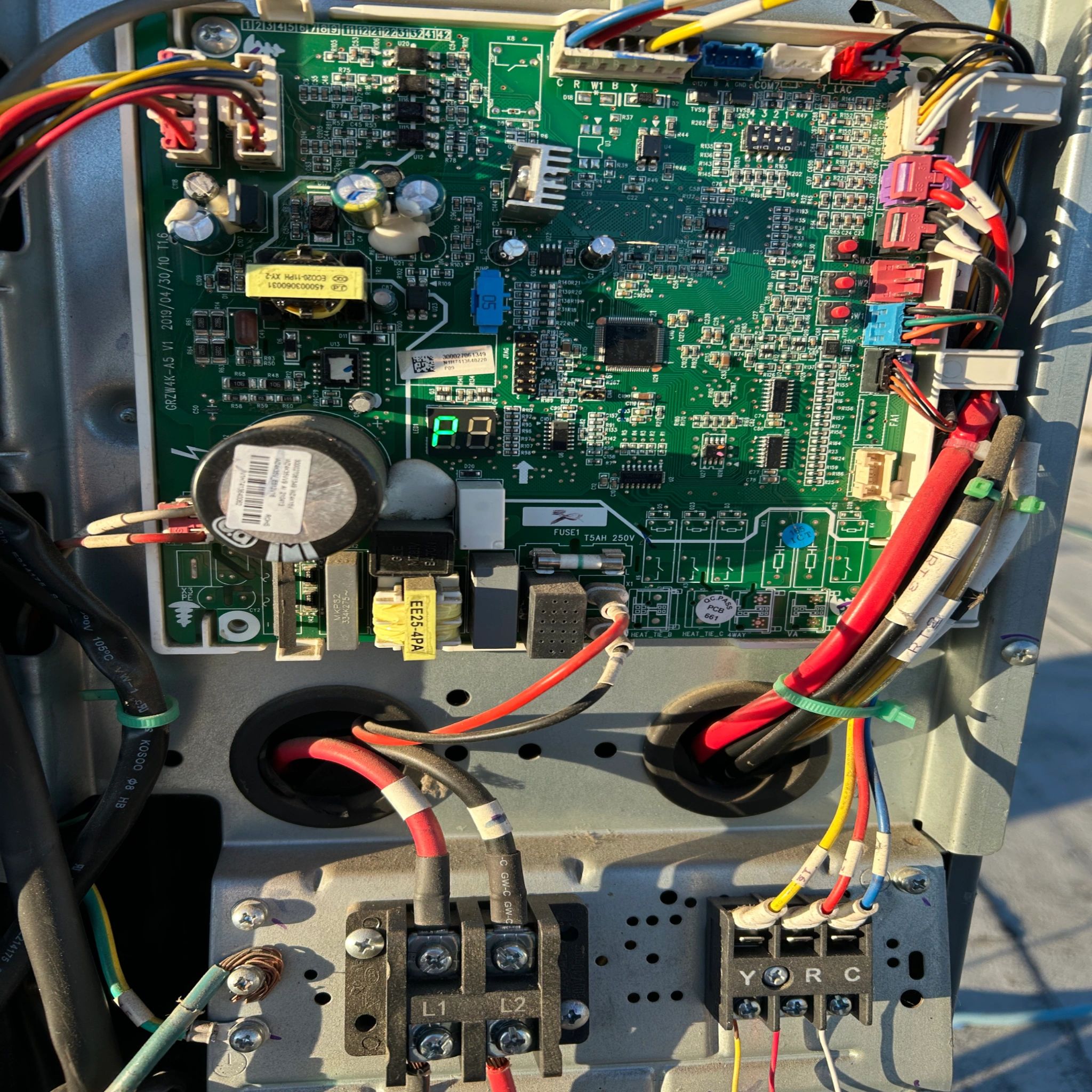 Close-up of an electrical control board with wires and components.