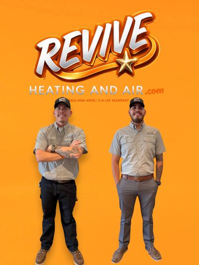 Two smiling technicians stand in front of a bright orange Revive Heating and Air backdrop.