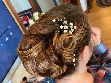 A woman in messy bun hairstyle and flowers