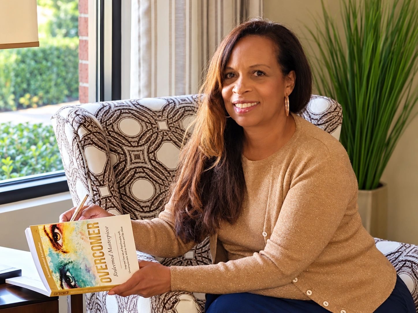 Charmene Vega is smiling while holding her book, Overcomer. #charmenevega #mamavega