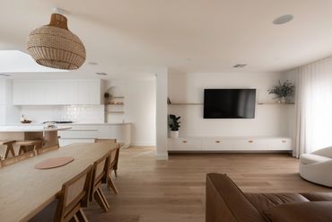 Modern open-plan living and dining area with minimalist design and natural wood tones.