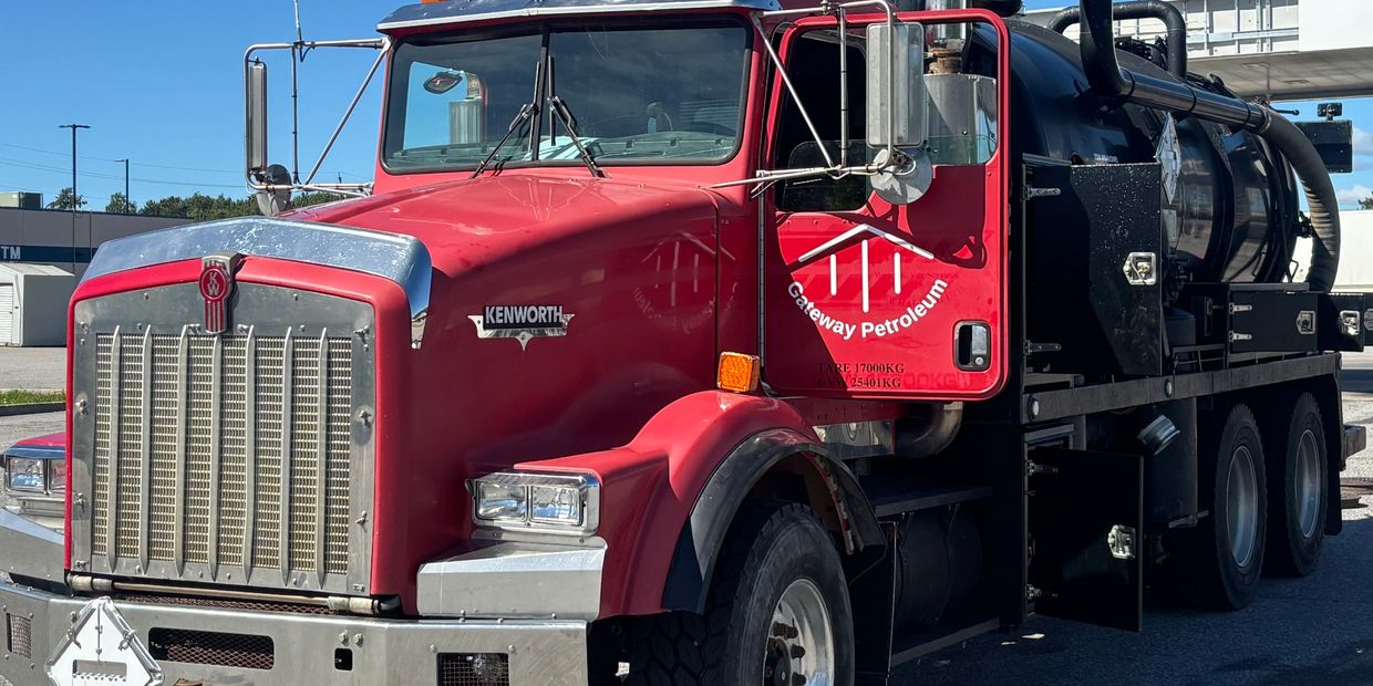 Gateway Petroleum Vac Truck image.  Red Kenworth Truck with vacuum hoses with Gateway Petroleum logo