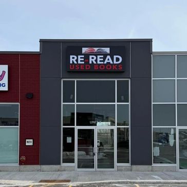 Storefront of RE-READ Used Books in a commercial strip.