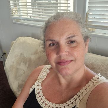 Smiling woman sitting on a couch indoors.