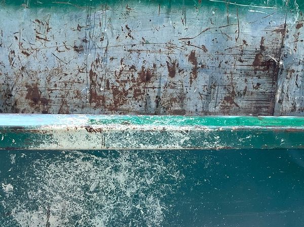 Rusty, scratched metal surface with green paint.