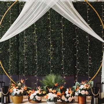 Elegant circular wedding arch with white drapes and floral arrangements.