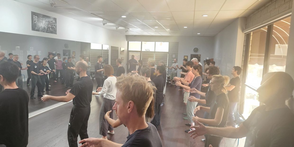 Group practicing Tai Chi in a studio.