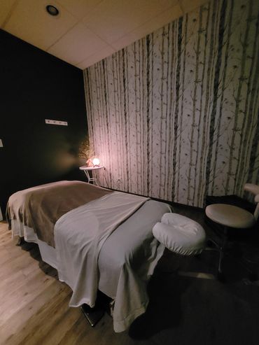Massage room with relaxing wall of trees and low lighting