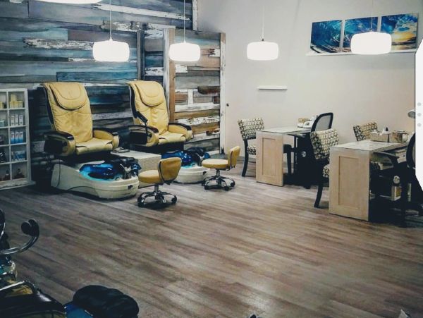 Modern nail salon interior with pedicure chairs and manicure stations.