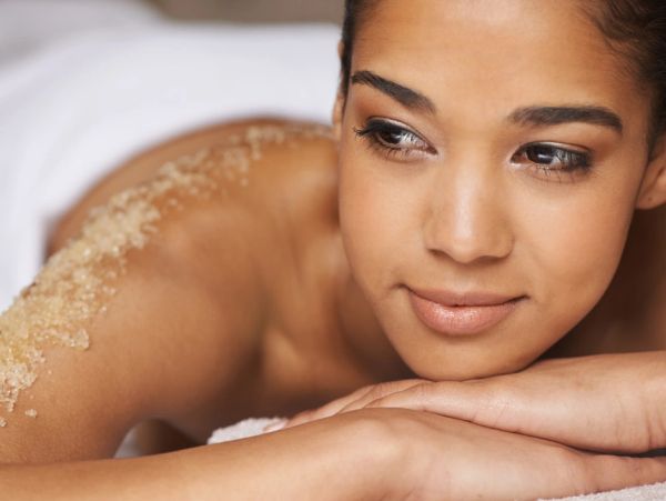 A woman enjoying a relaxing body scrub treatment at a spa.