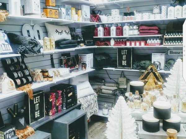 Cozy home decor and wellness products displayed on shelves and tables.