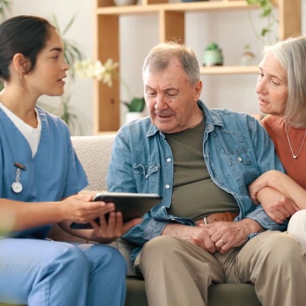 An elderly patient is learning to use technology to connect with their care team and access support. 