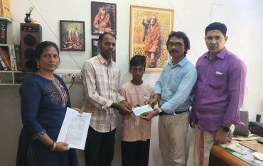 Group of five people exchanging documents in an office setting.
