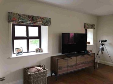 A livingroom with bespoke, professionally made interlined roman blinds