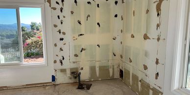 Room under renovation with exposed pipes and unfinished walls.