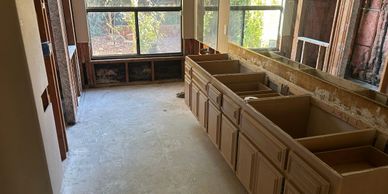 Bathroom under renovation with stripped walls and cabinetry.
