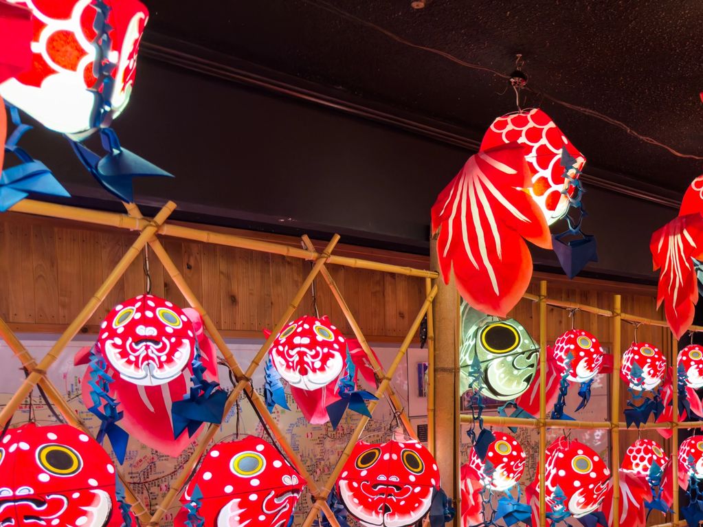 Vibrant red and white fish-shaped lanterns hanging indoors.
