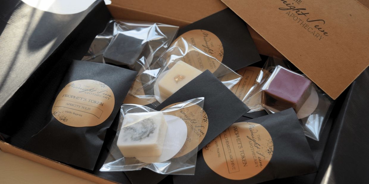 A box containing assorted handmade apothecary products with labels.