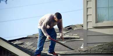 A man taking off an old roof on a home