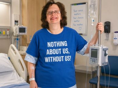 Patient wearing a blue shirt with a powerful message in a hospital room.
