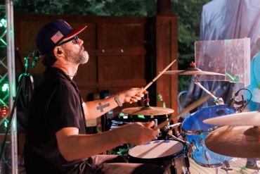 Drummer playing passionately on stage.