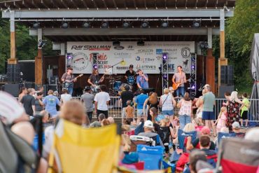 Outdoor concert with band and audience.