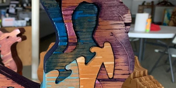 Colorful wooden puzzle pieces shaped like cats stacked together.