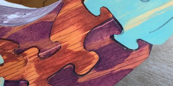 Close-up of colorful interlocking wooden puzzle pieces.