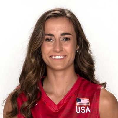 Female athlete smiling in a red USA sports jersey.