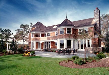 Large two-story house with wooden siding and spacious lawn.