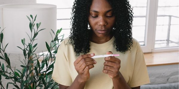 A woman is staring at a pregnancy test.