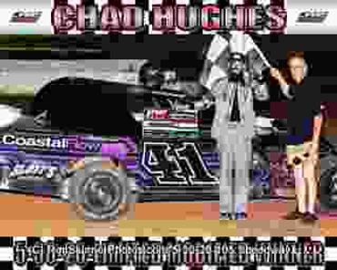 Race car driver Chad Hughes celebrates victory with officials by his car.