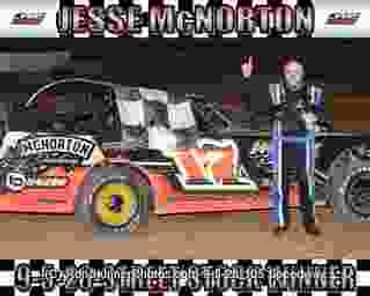 Race car driver Jesse McNorton celebrates a win on the podium.